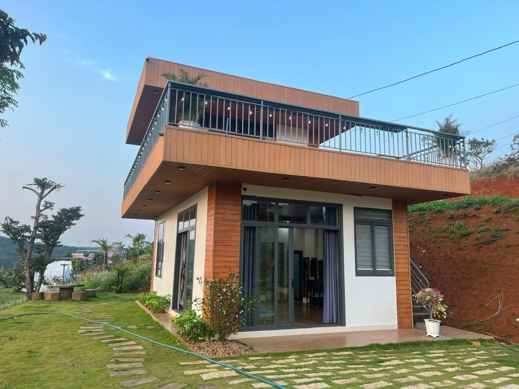 a house with a balcony on top of it at Dak Nguyen Homestay & Farm 3 in Gia Nghĩa