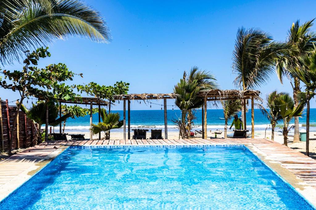 a swimming pool with the beach in the background at Mamaqocha in Canoas De Punta Sal