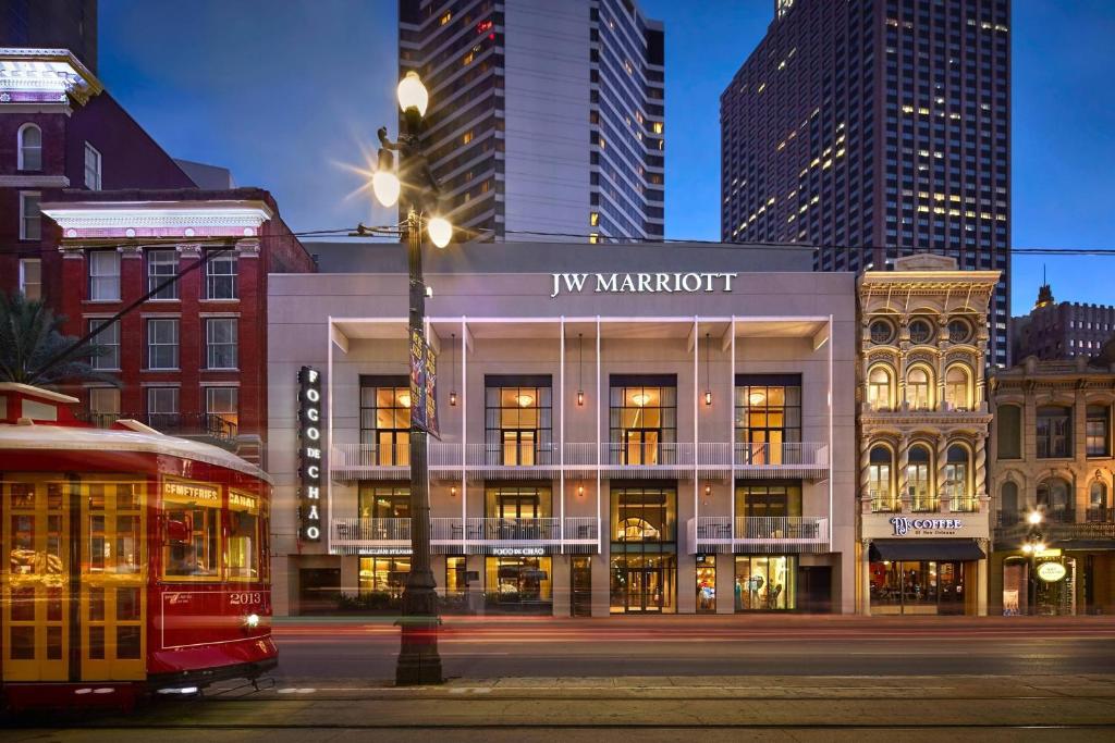 a building on a street with a bus in front at JW Marriott New Orleans in New Orleans