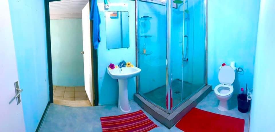 a blue bathroom with a sink and a shower at Haranai Camping & Tours in Te-Fare-Arii