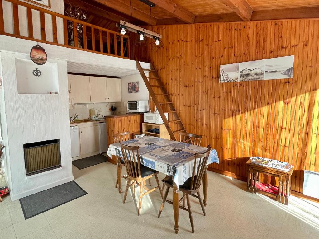 une cuisine et une salle à manger avec une table et un escalier dans l'établissement Maison de Vacances avec Piscine Chauffée, Tennis et Proximité Mer à Bretignolles-sur-Mer - FR-1-231-309, à Bretignolles-sur-Mer
