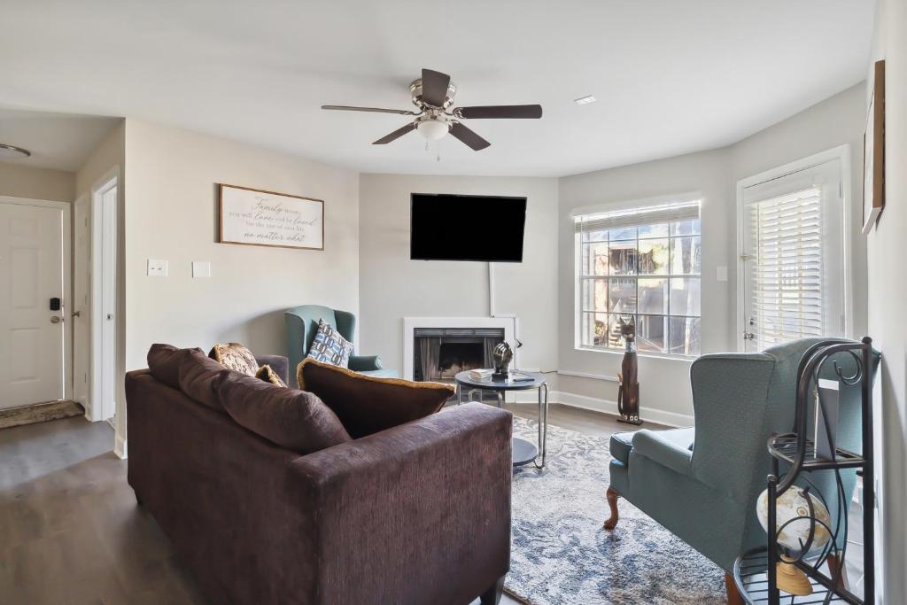 a living room with a couch and a tv at Center City Charm, the place to meet all of your needs in Huntsville