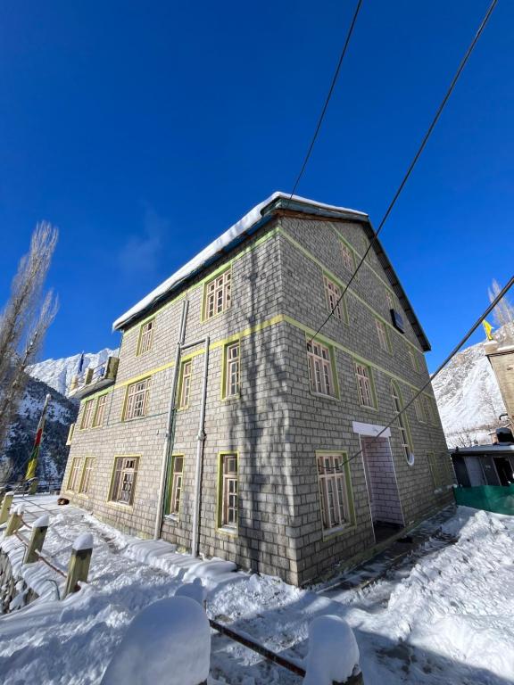 Gondla的住宿－SNOWFLAKE Homestay，积雪覆盖着一块大砖头的建筑