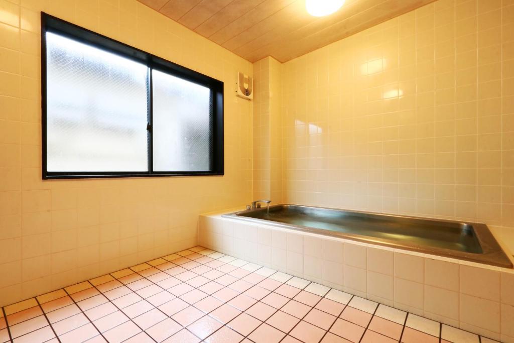 bagno con vasca e finestra di 民宿ふくだ a Minamiōsaka