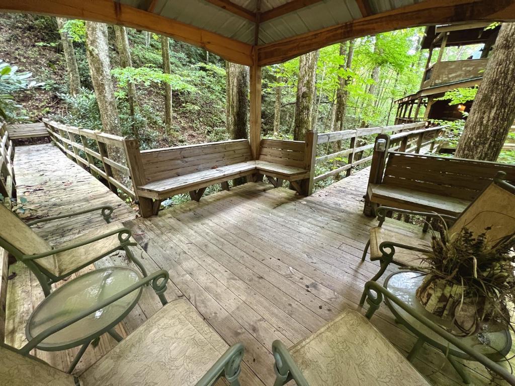 a porch of a cabin with benches and trees at Streamsong Secluded Creek View Cabin in Hatchertown