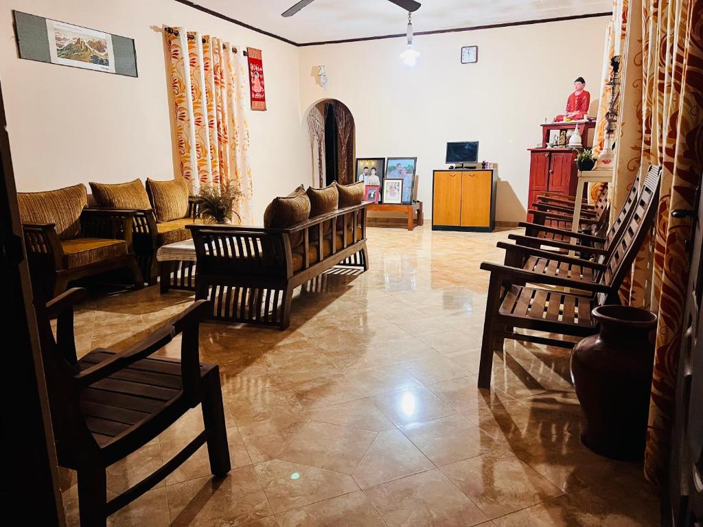 sala de estar con varias sillas y sofá en Cozy village house en Tudugalla