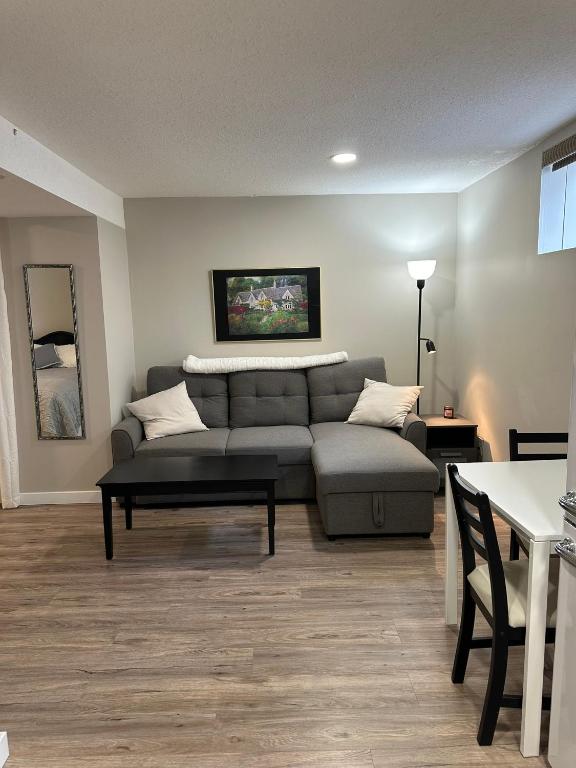 Entire Basement Guest Suite In Cranbrook في كرانبروك: غرفة معيشة مع أريكة وطاولة