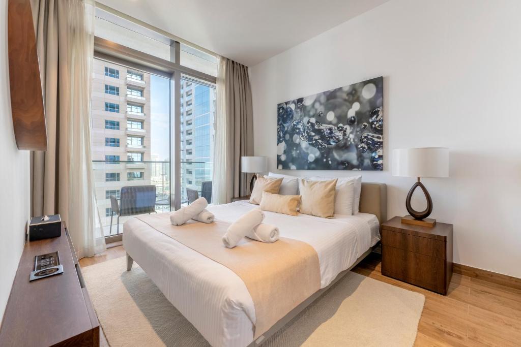 a bedroom with a large bed with a large window at Jumeirah Marina Gate Residences in Dubai