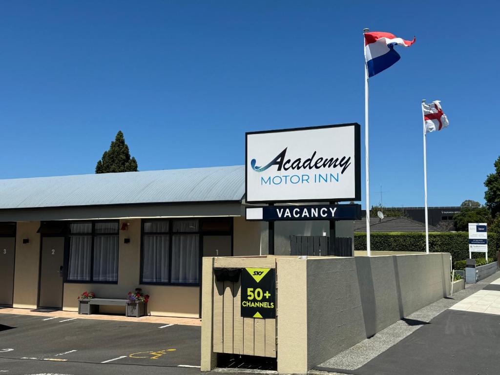 Schild mit der Aufschrift aania Motor Inn vor einem Gebäude in der Unterkunft Academy Motor Inn in Tauranga
