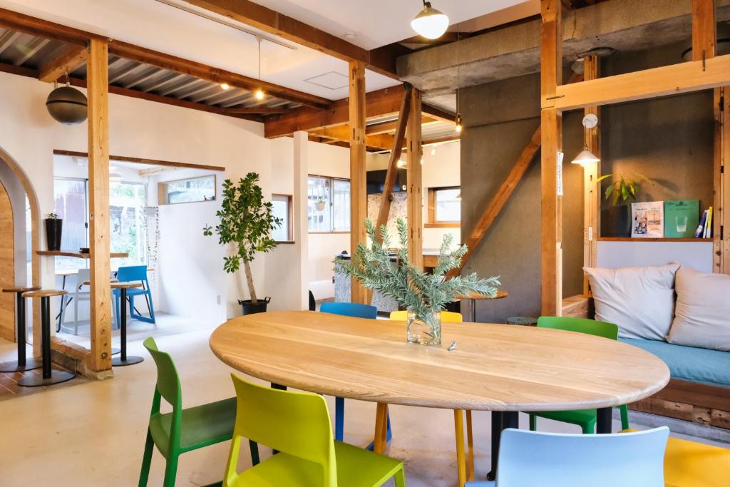 a dining room with a wooden table and green chairs at palette in Numazu