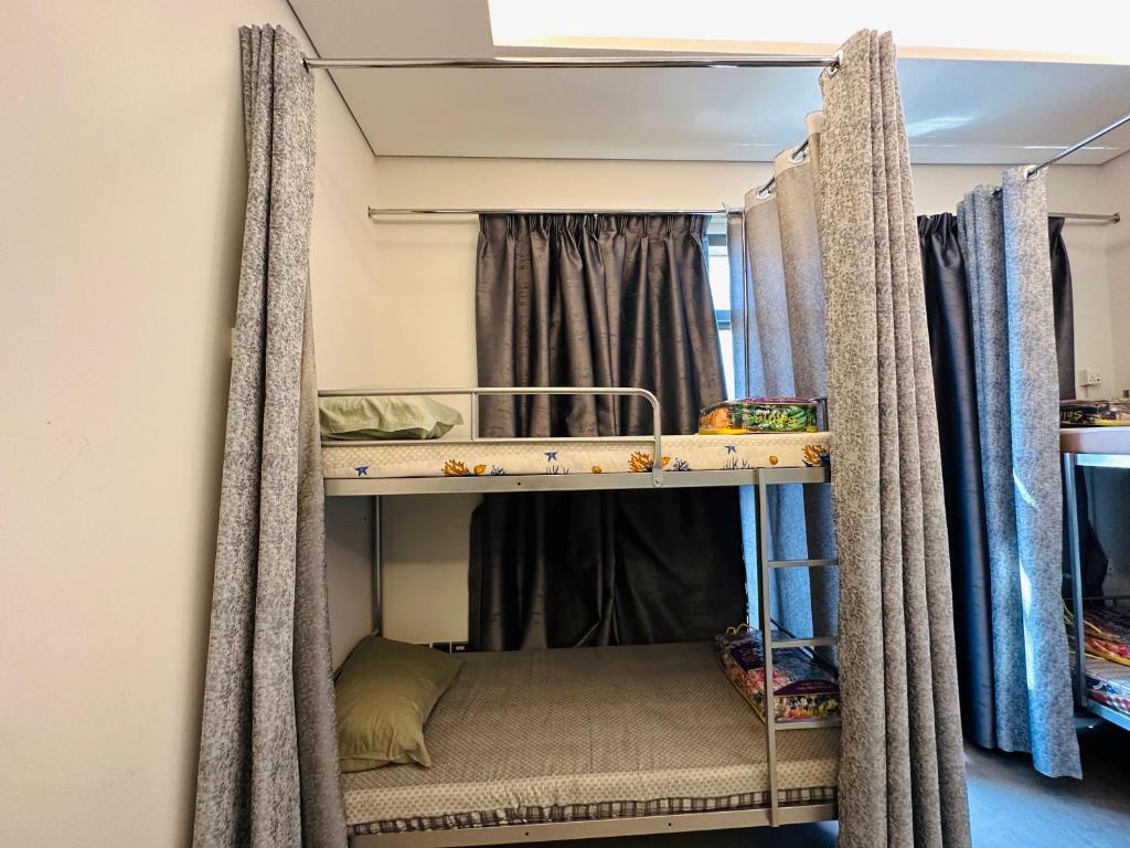 Pokój z 2 łóżkami piętrowymi i zasłonami w obiekcie OVAL TOWER w Dubaju