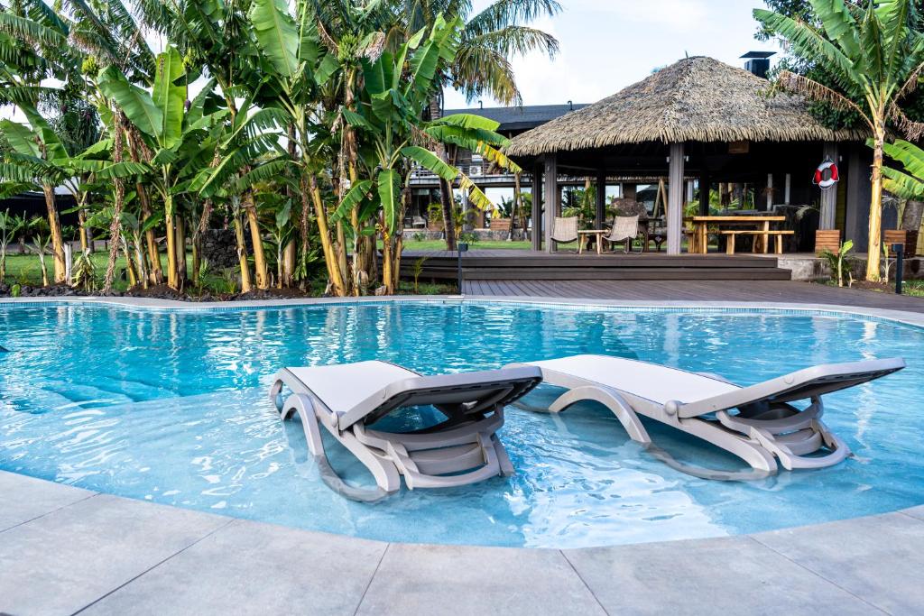 a swimming pool with two lounge chairs in the water at Hotel Ohana Rapa Nui in Hanga Roa