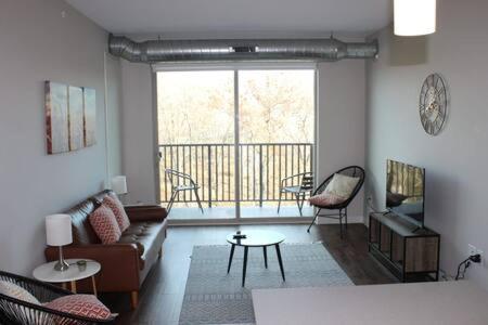 ein Wohnzimmer mit einem Sofa und einem Balkon in der Unterkunft Onsite coffee bar just mins to Jack Thrice Stadium in Ames