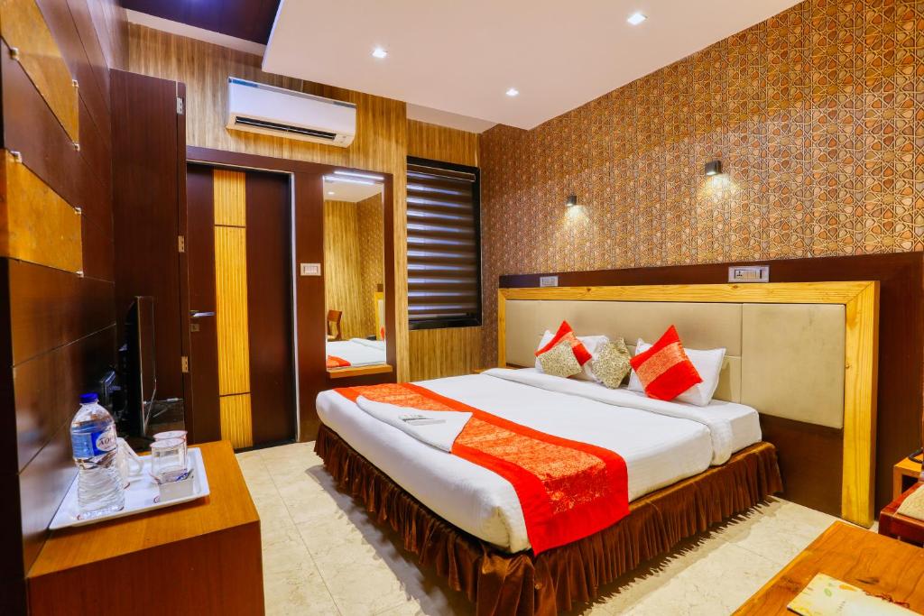 a hotel room with a large bed and a television at The Ashoka Hotel in Indore