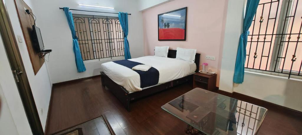 a bedroom with a bed and a glass table at Savi's home stay in Ooty