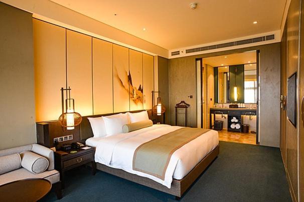 sypialnia z dużym łóżkiem i kanapą w obiekcie New World Hotel w mieście Butwāl