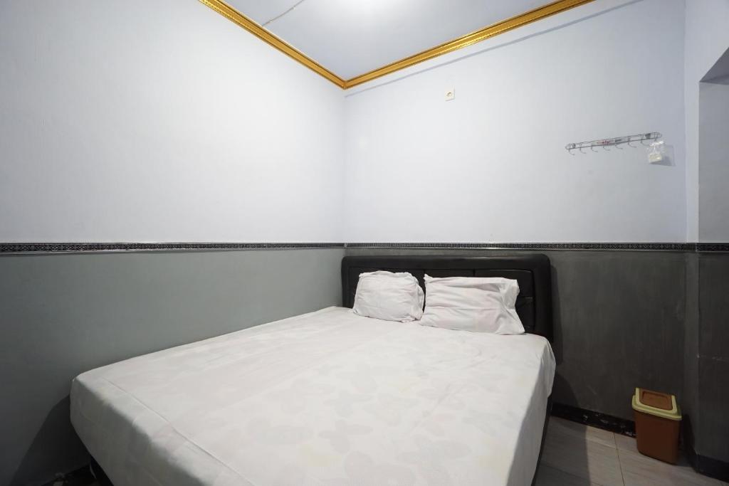 małe łóżko z 2 poduszkami w pokoju w obiekcie OYO 93628 Scorpion Guest House & Beach w mieście Tulungagung