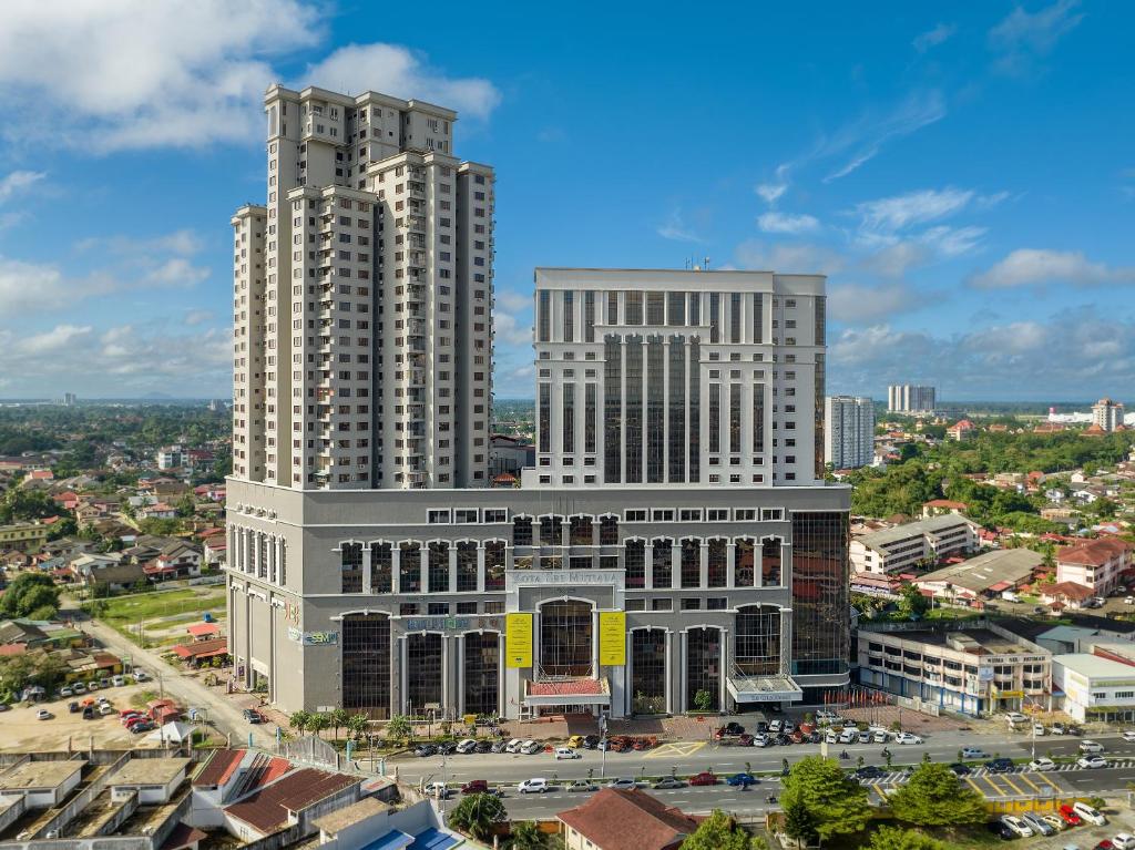 due alti edifici bianchi in una città con traffico di Renai Hotel Kota Bharu a Kota Bharu