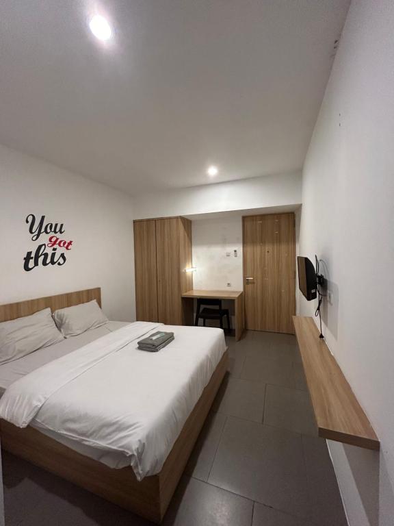 um quarto com uma cama grande e uma secretária em Behomy Maxley Lippo Karawaci em Tangerang