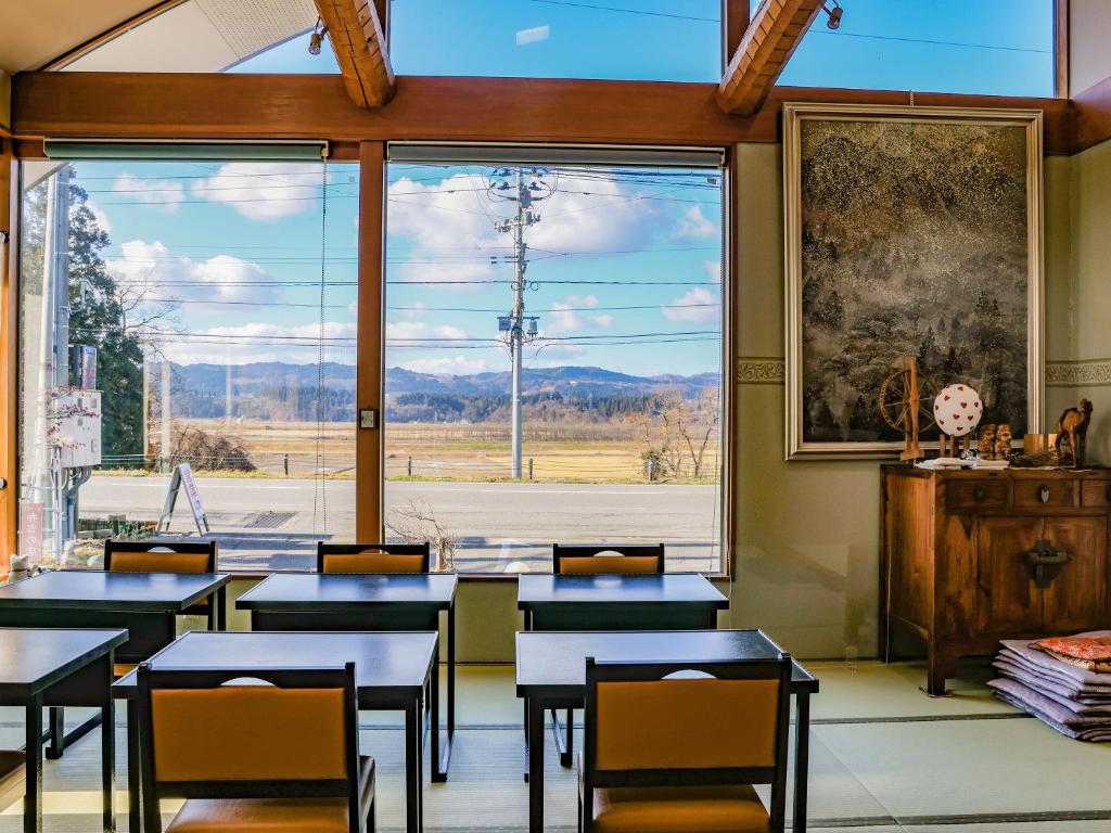 a classroom with tables and chairs and a large window at Bandai in Tokamachi