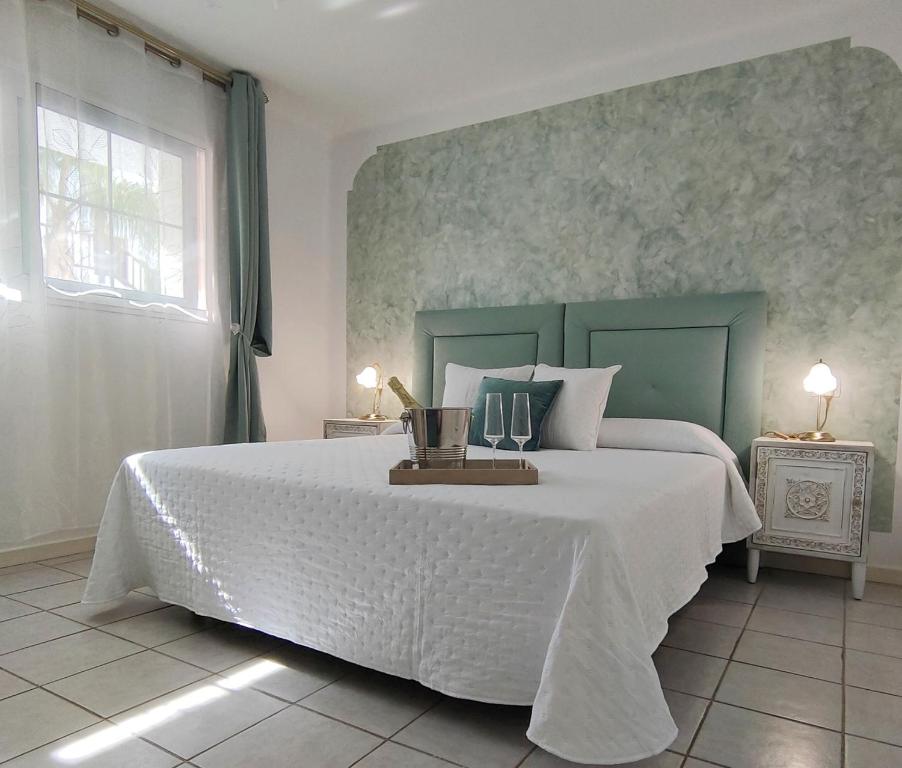 1 dormitorio con cama blanca y cabecero verde en Rocas del Mar 327, en Costa del Silencio