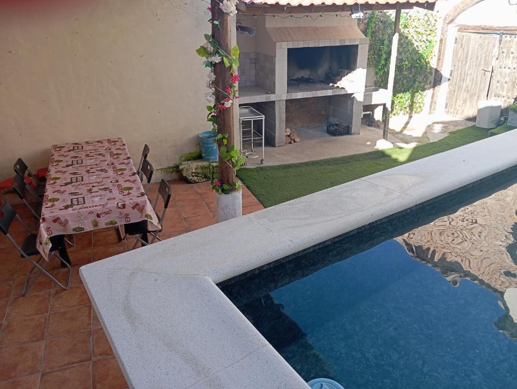 una piscina con mesa y chimenea en Casa de Campo Ismael, en El Acebrón