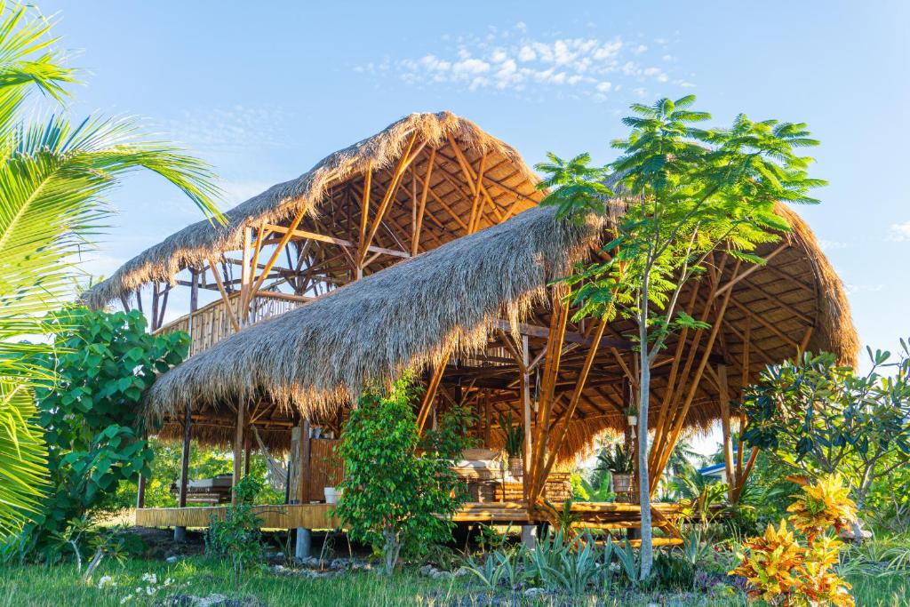 uma cabana com um telhado de palha e algumas árvores em Tongo Hill Cottages em Moalboal