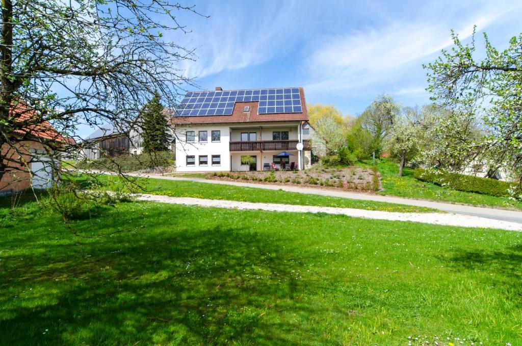 ein Haus mit Sonnenkollektoren auf dem Dach in der Unterkunft Ferienwohnung Kobelsberg in Aufseß