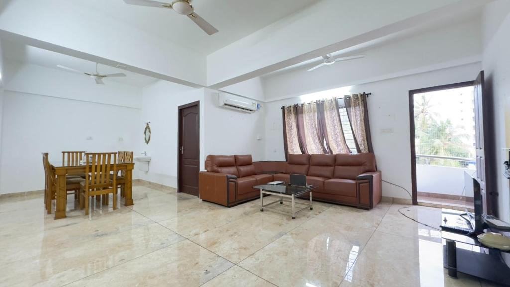 een woonkamer met een bank en een tafel bij Downtown Manor-Panavila in Trivandrum