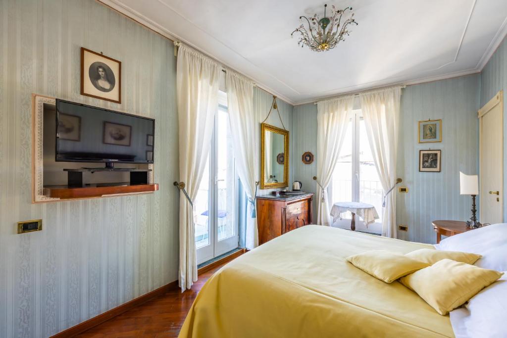 ナポリにあるLa Casa Di Bruno Napoliのベッドルーム1室(ベッド1台、壁にテレビ付)