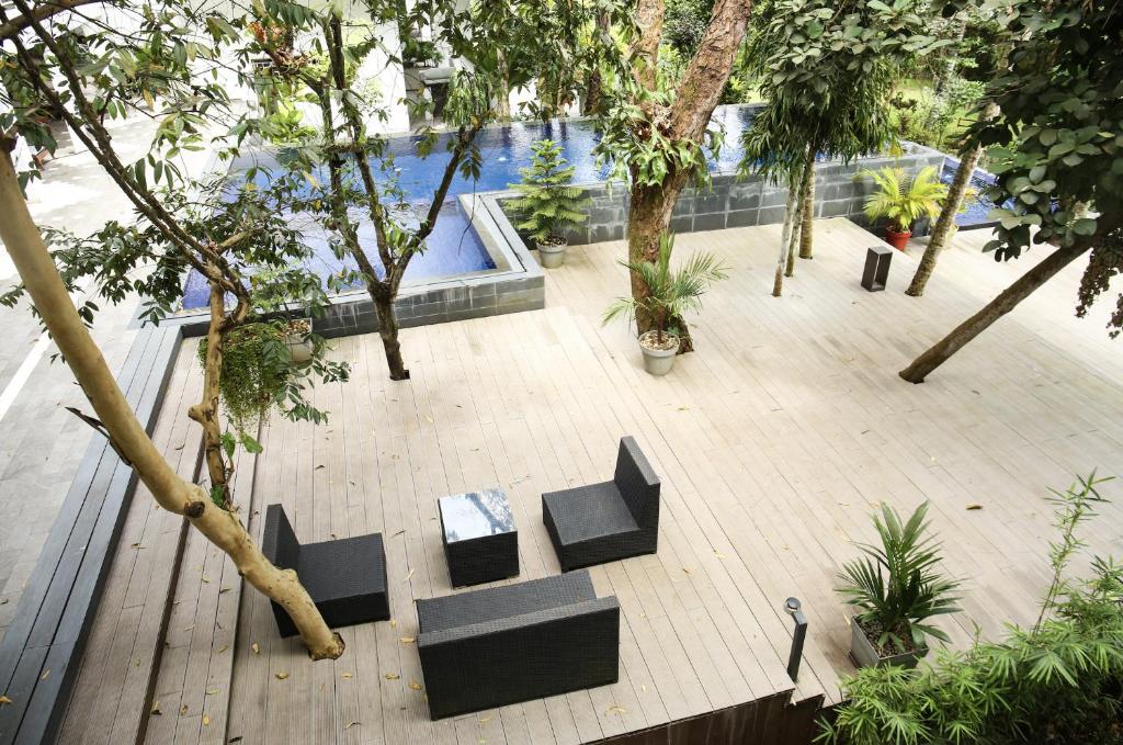 an outdoor area with chairs and trees and a pool at Hotel Lepic in Abidjan