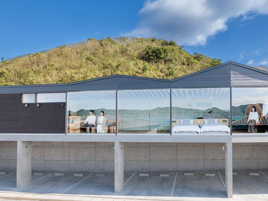 a tent on a building with a mountain in the background at Denpaku The Beachfront MIJORA in Amami