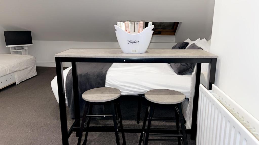 a table with two stools next to a bed at Sunrise Retreat in London