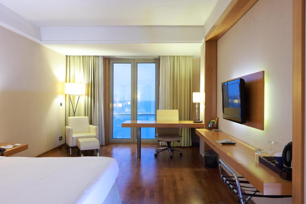 a hotel room with a bed and a desk with a television at Anemon Ordu in Ordu