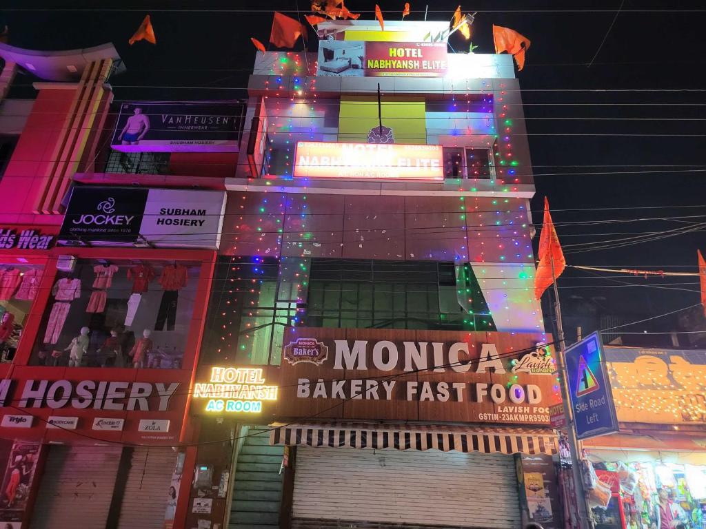 OYO Nabhyansh Elite في إندوري: مبنى كبير مع أضواء ملونة عليه في الليل