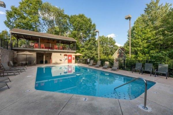 une grande piscine avec une maison en arrière-plan dans l'établissement Hey Diddle Diddle cabin, à Pigeon Forge