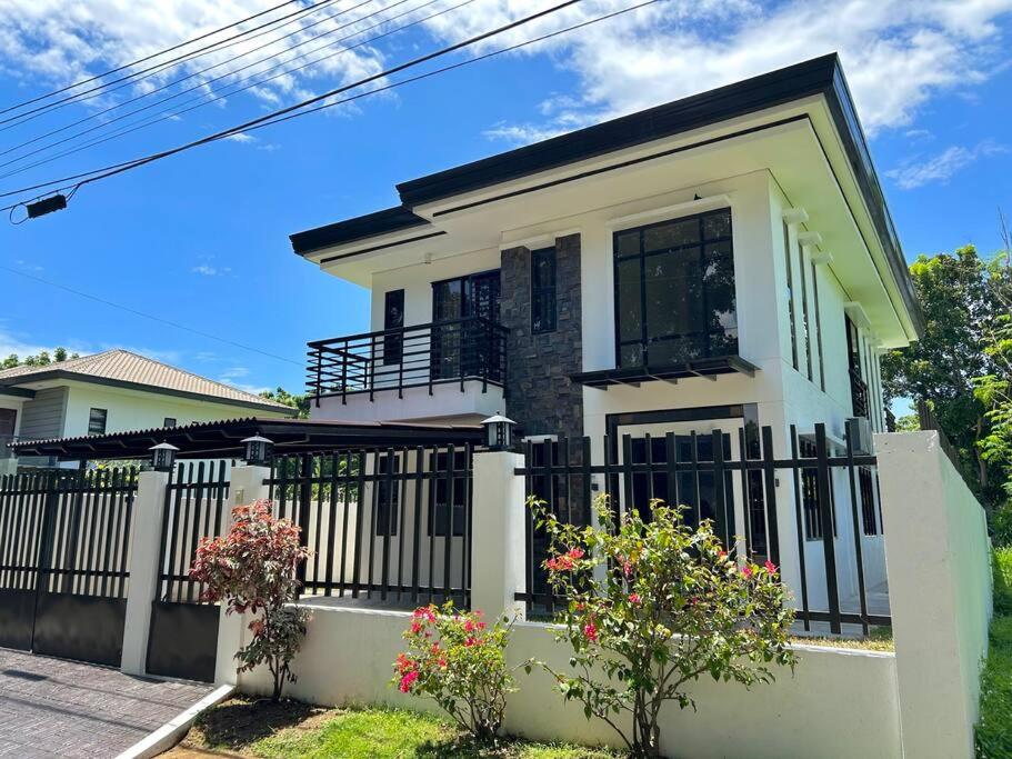 ein weißes Haus mit einem schwarzen Zaun in der Unterkunft Solitary Golf Home w/ Pool in Davao City