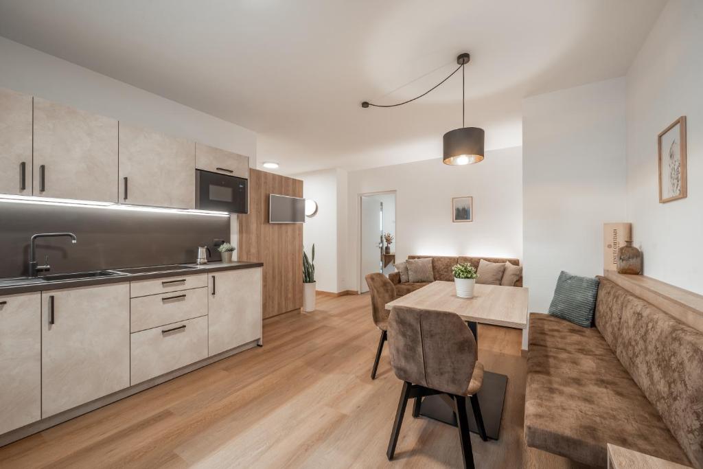 uma cozinha e sala de estar com uma mesa e um sofá em Ferienapartments Tramin Z1 em Termeno