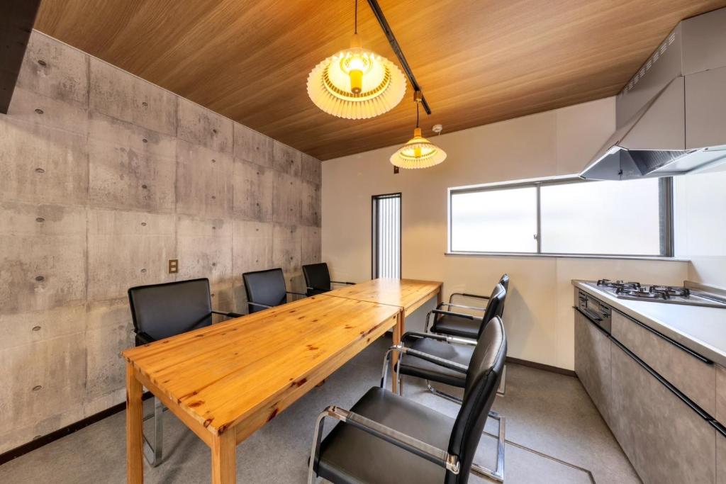 ein Esszimmer mit einem Holztisch und Stühlen in der Unterkunft Yoshimura igariya in Azagawa