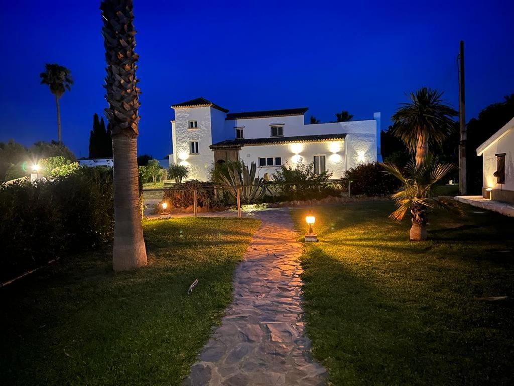 een huis met een palmboom en een loopbrug bij Hotel Finca Duende - Adults Only in Hozanejos