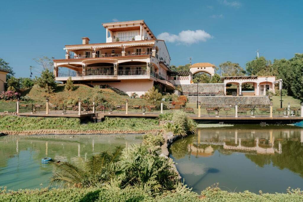 une maison sur une colline avec un pont sur une rivière dans l'établissement The Palazzo by Villa Deste, à Tagaytay