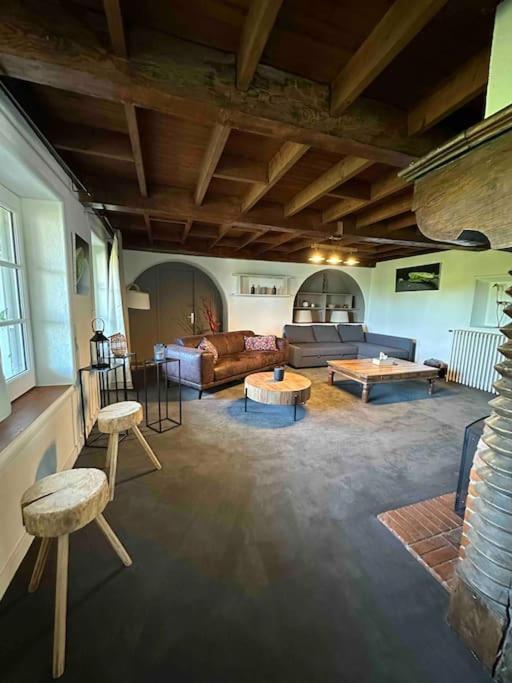 un grand salon avec un canapé et des tables dans l'établissement Appartement avec grande terrasse, à Saint-Alban-les-Eaux