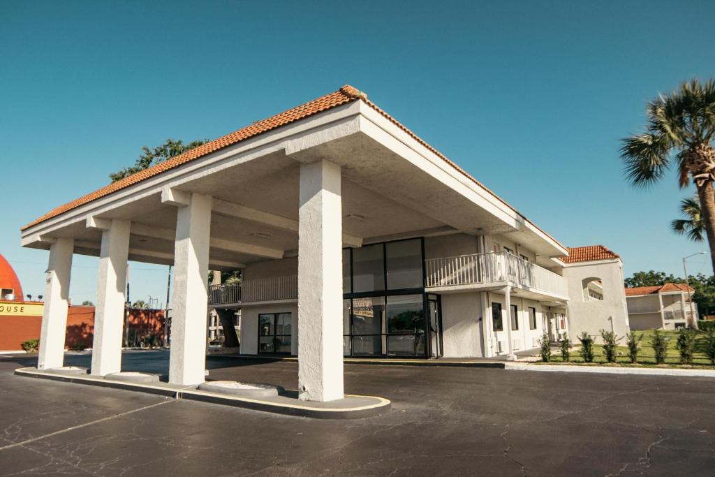 een gebouw met een parkeerplaats ervoor bij Developer Inn Express Fundamental, a Travelodge by Wyndham in Kissimmee