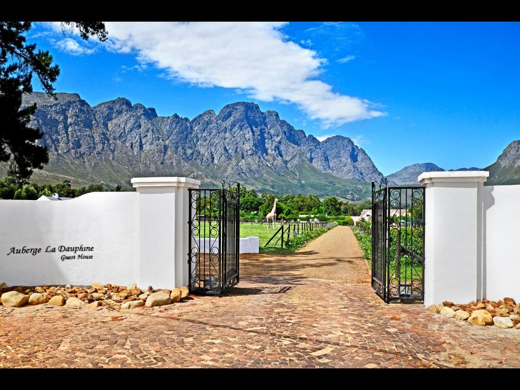 an open gate with mountains in the background at Auberge La Dauphine Guest House in Franschhoek