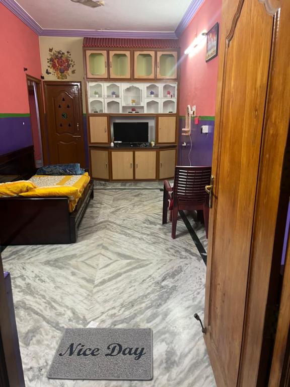 uma sala de estar com um belo sinal de dia na porta em SM Homestays 2 em Tirupati