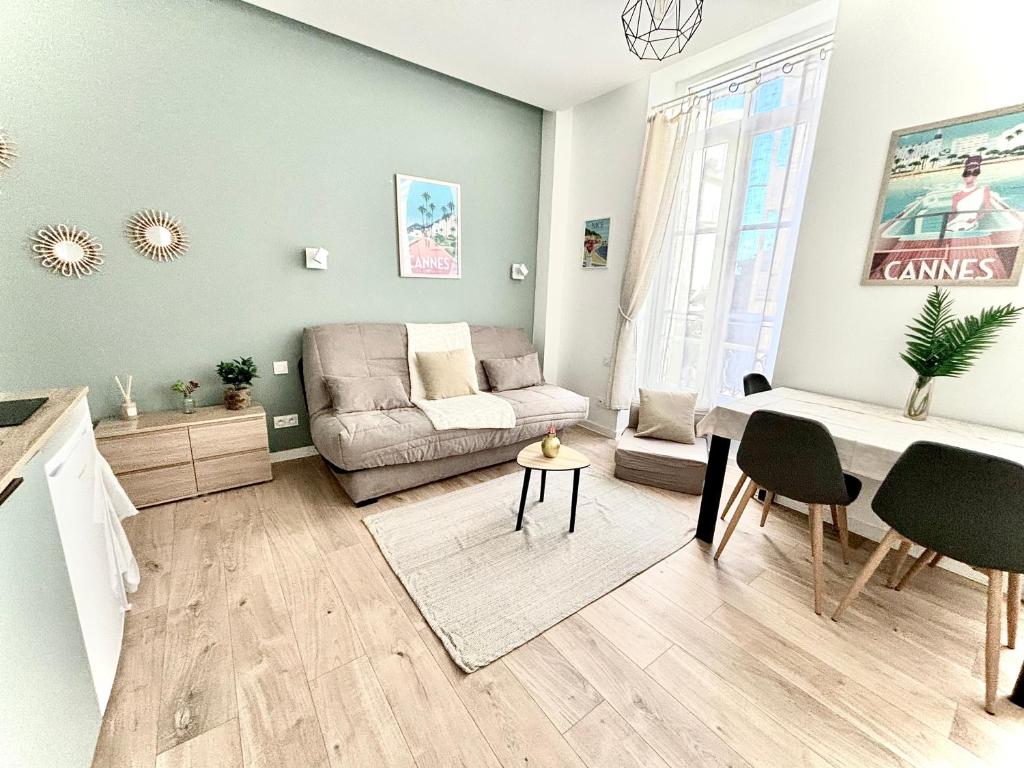 ein Wohnzimmer mit einem Sofa und einem Tisch in der Unterkunft Studio center 104 in Cannes