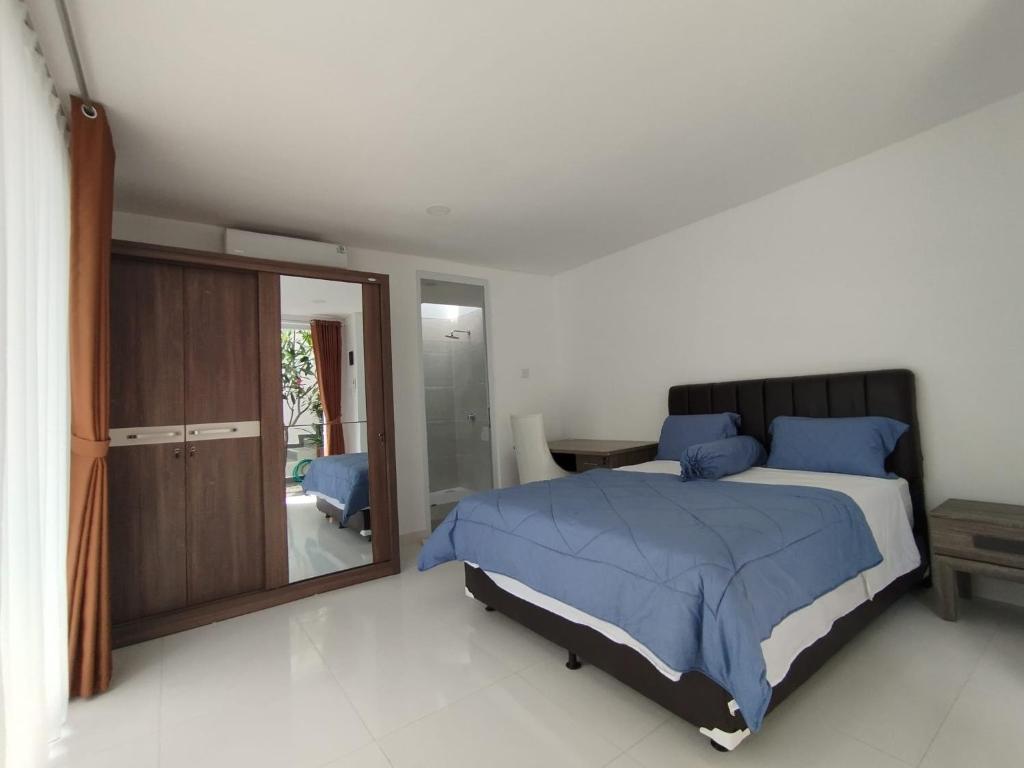a bedroom with a large bed and a mirror at Rumah Menik in Uluwatu