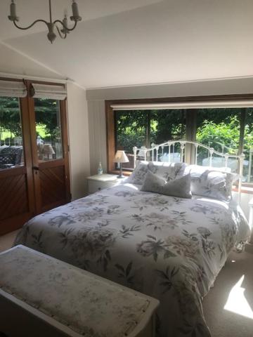 ein Schlafzimmer mit einem Bett und einem großen Fenster in der Unterkunft McIvor Lodge in Invercargill