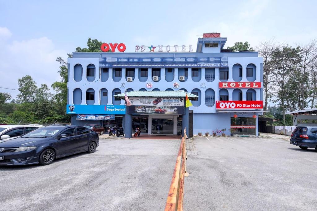 un edificio blu con macchine parcheggiate di fronte di Star Hotel a Port Dickson