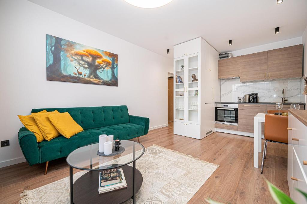a living room with a green couch and a table at Apartment near Buivydiškės lakes in Vilnius